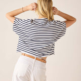 Person wearing a black and white striped shirt with a beige background
