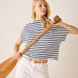 Woman holding a wooden oar against a plain background