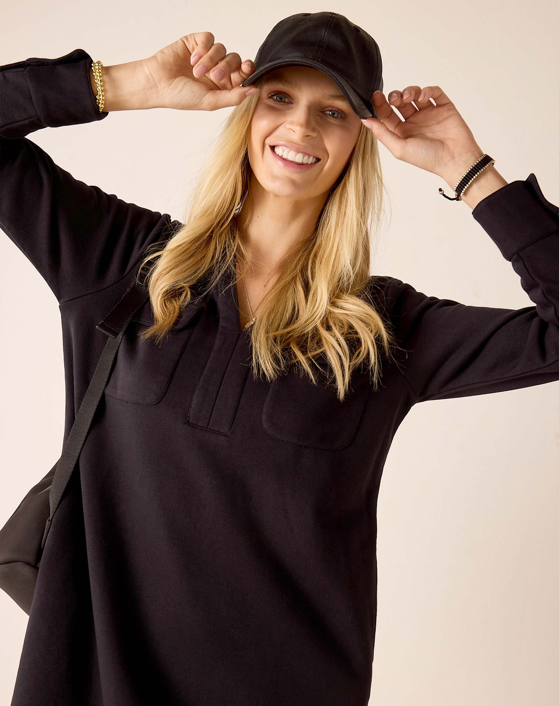 Women's travel-friendly black long-sleeve tunic with front pockets and a buttoned placket.
