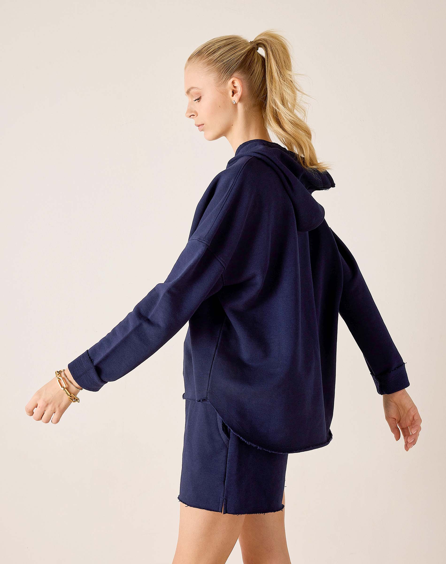 Side view of women's travel-friendly cadet blue hoodie with a drawstring hood and matching shorts.