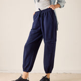 Person wearing navy cargo pants with a neutral background