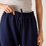 Navy blue pants with a drawstring waist worn by a person on a neutral background