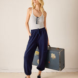 Woman holding a vintage suitcase against a plain background
