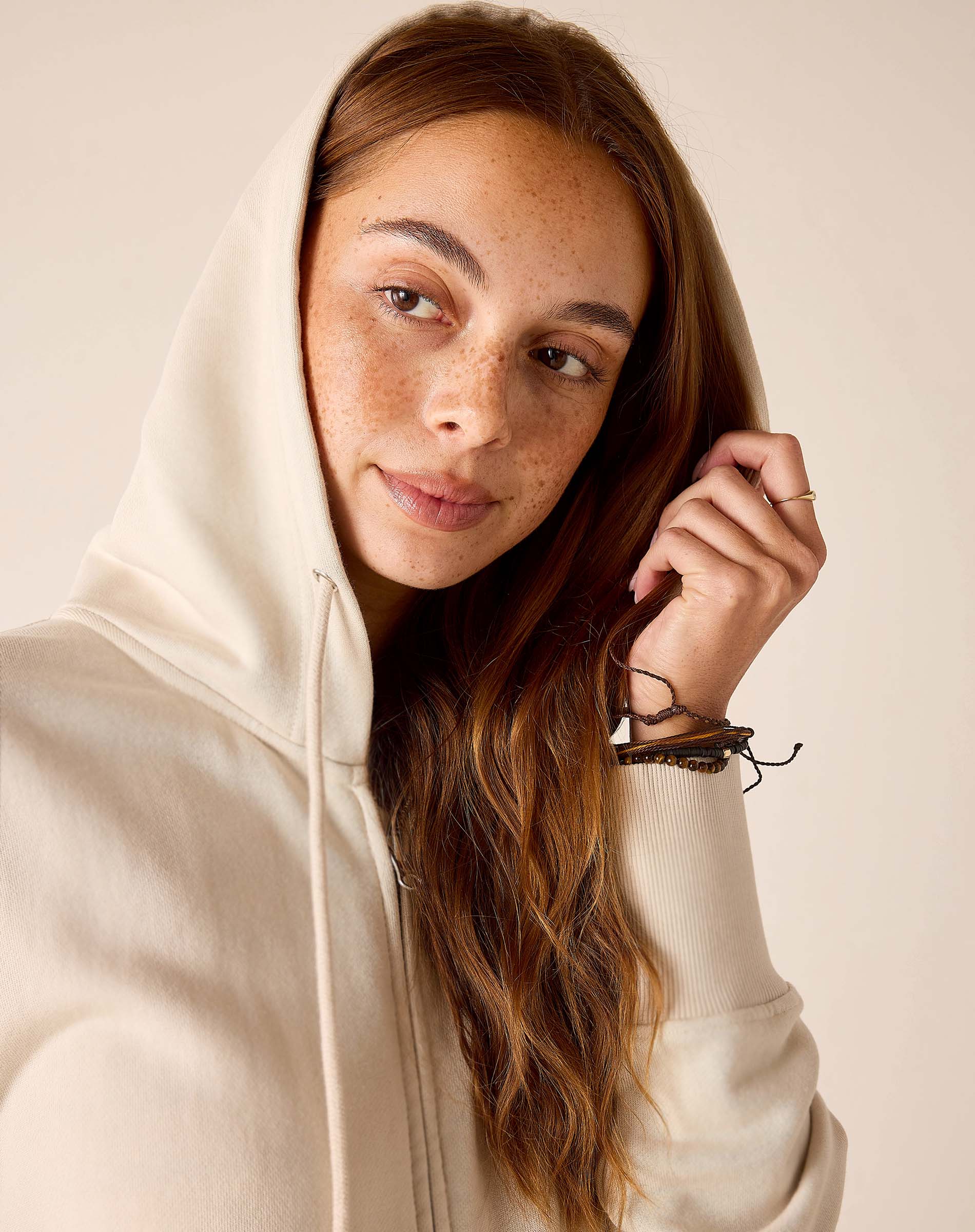 Bone hoodie with a drawstring hood and cozy knit fabric.
