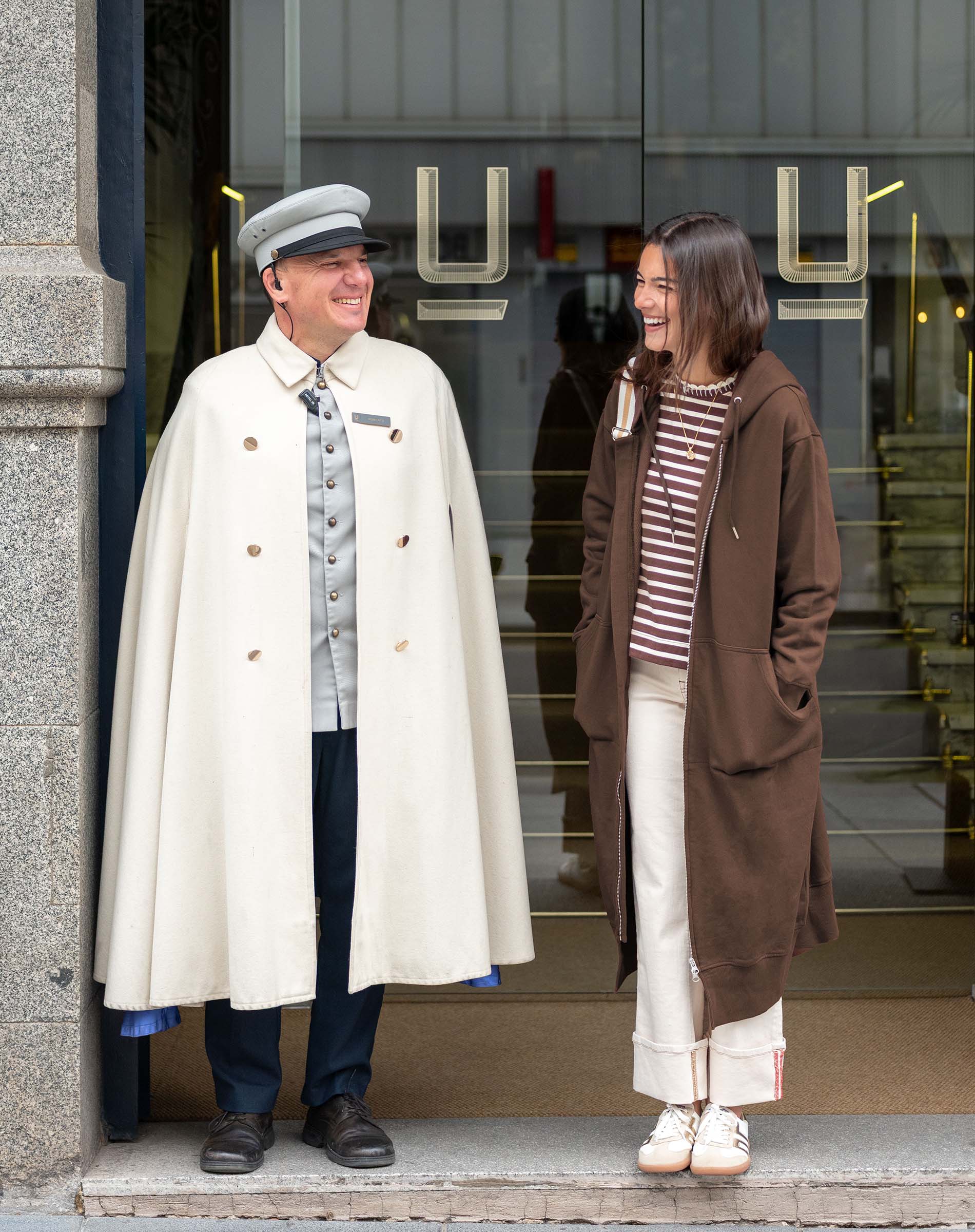 Espresso maxi hoodie with hood and front pocket worn by a woman in a city setting.