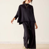MERSEA ladies' travel-ready black mockneck knit top with a relaxed fit and long sleeves.