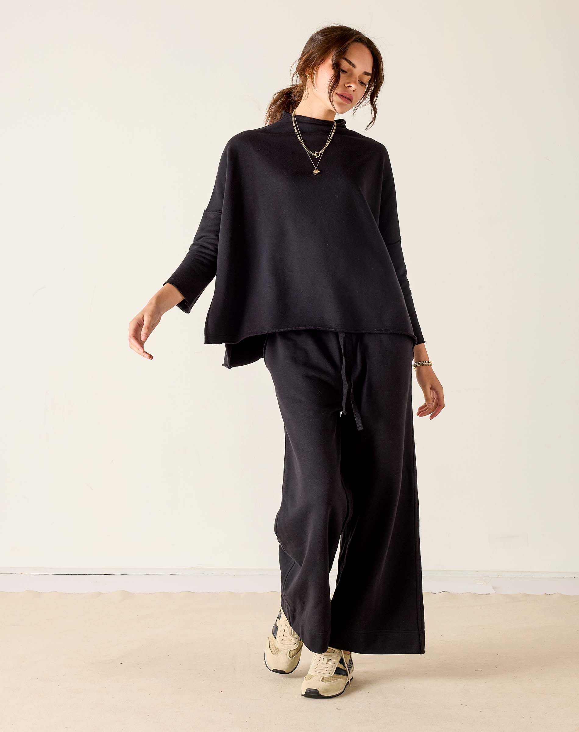 MERSEA ladies' travel-ready black mockneck knit top with a relaxed fit and long sleeves.