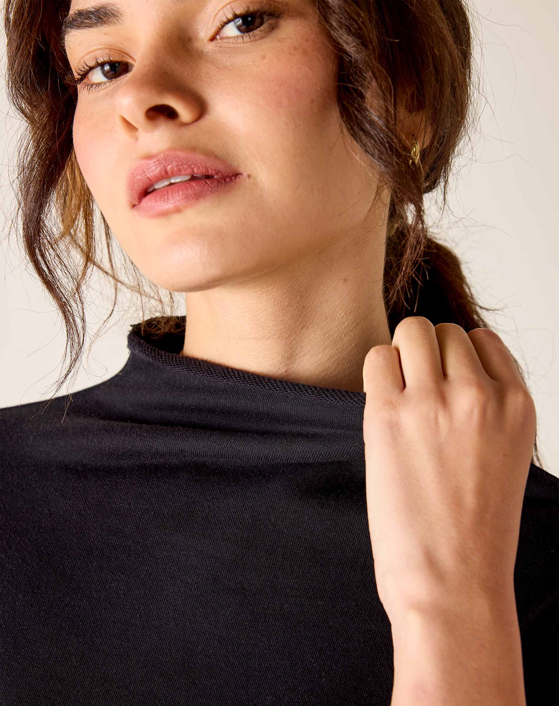 Woman wearing a black turtleneck with a neutral background