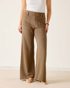 Person wearing brown wide-leg pants on a plain background