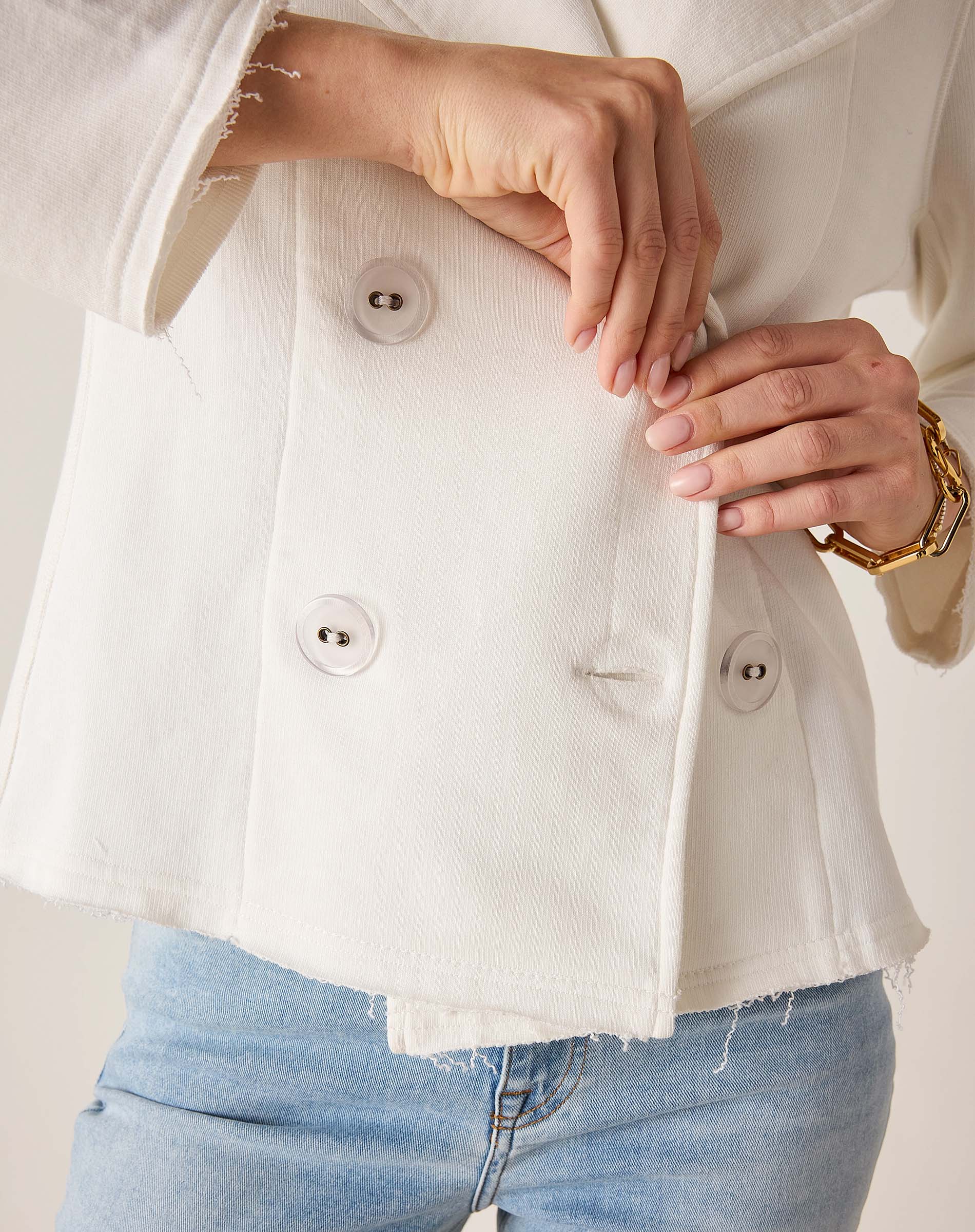 Model wearing a white frenchie peacoat over light blue denim jeans.