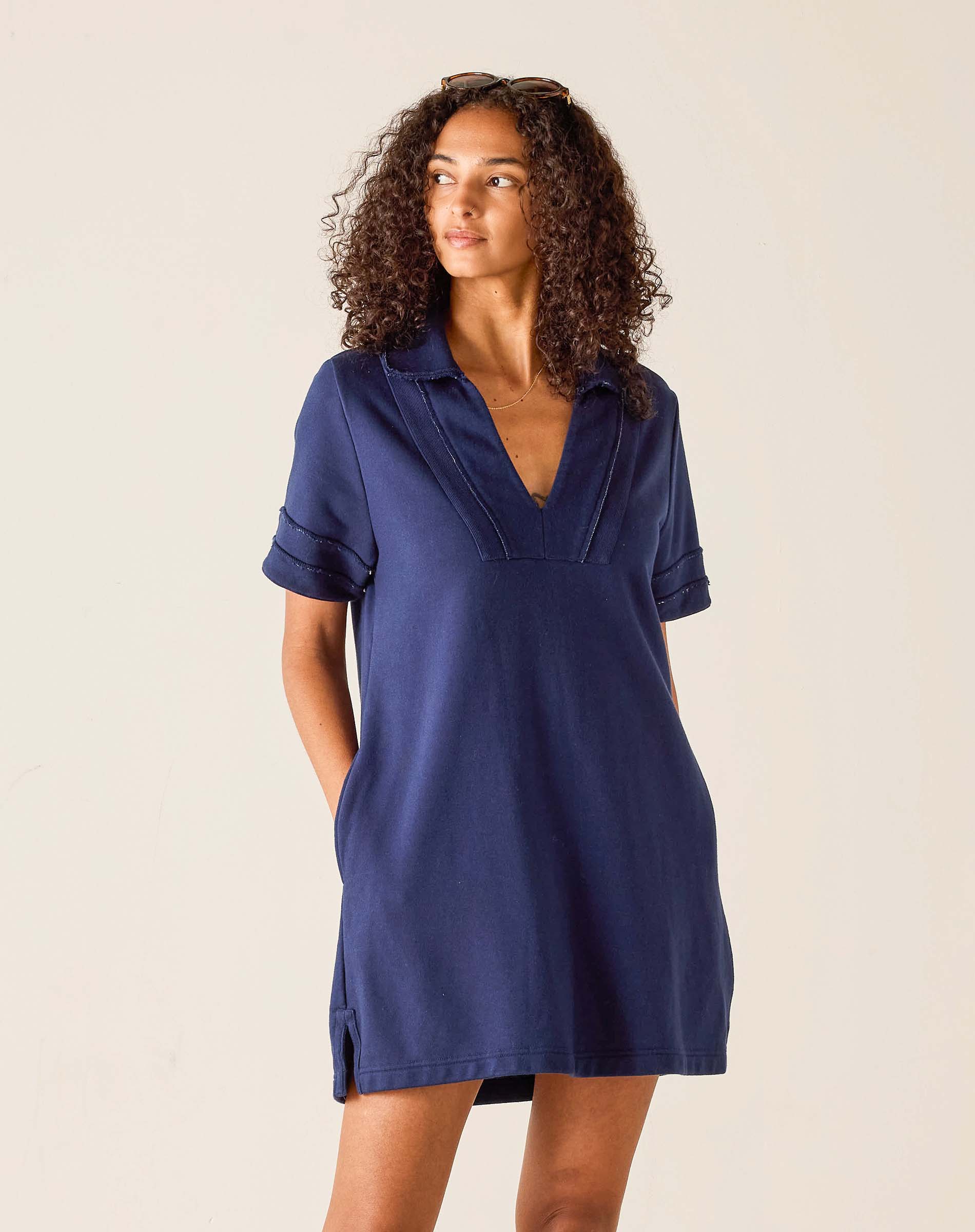 Woman wearing a navy blue dress against a beige background