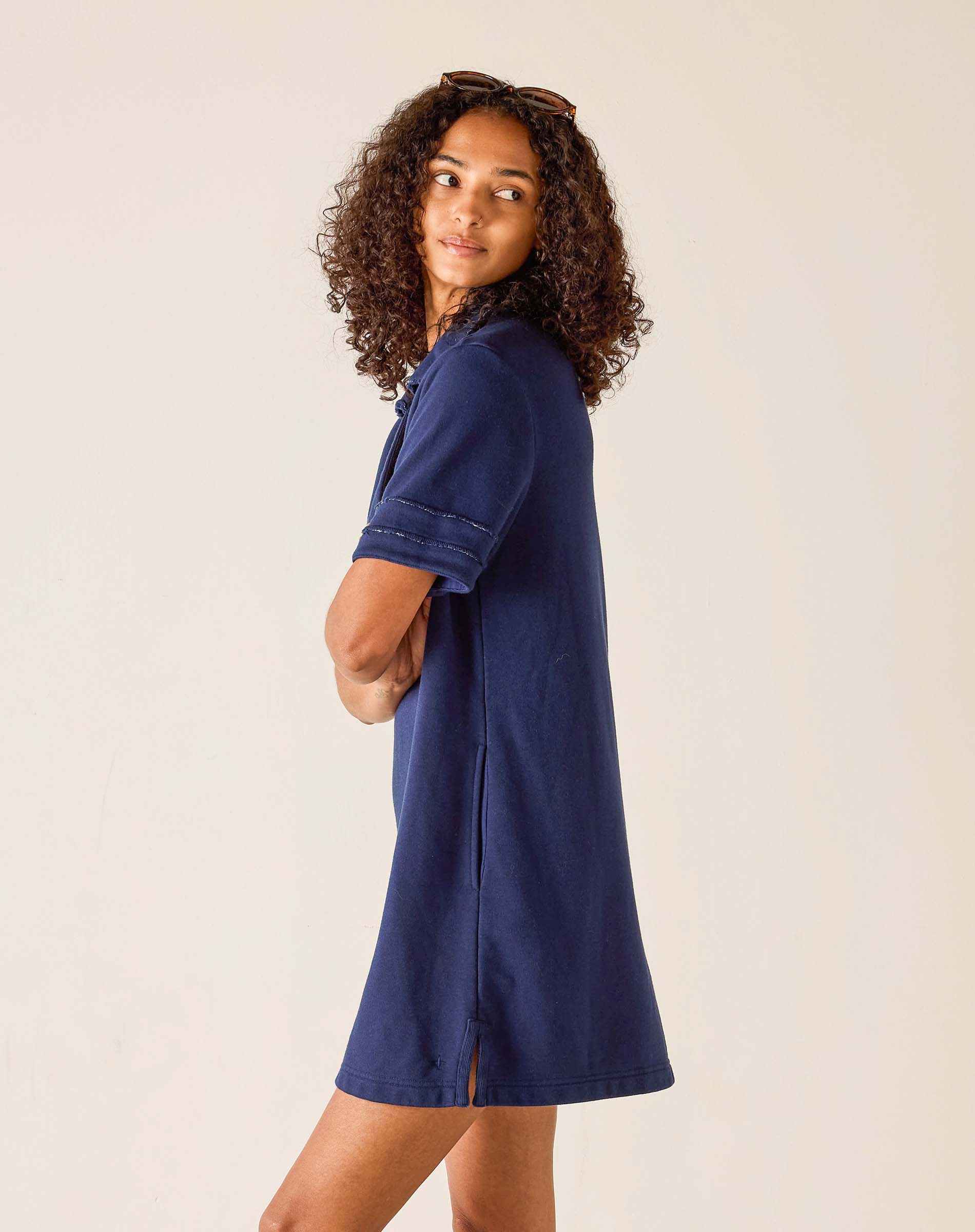 Woman wearing a blue dress against a plain background