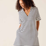 Woman wearing a black and white striped dress against a plain background