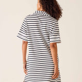 Woman wearing a black and white striped dress on a beige background