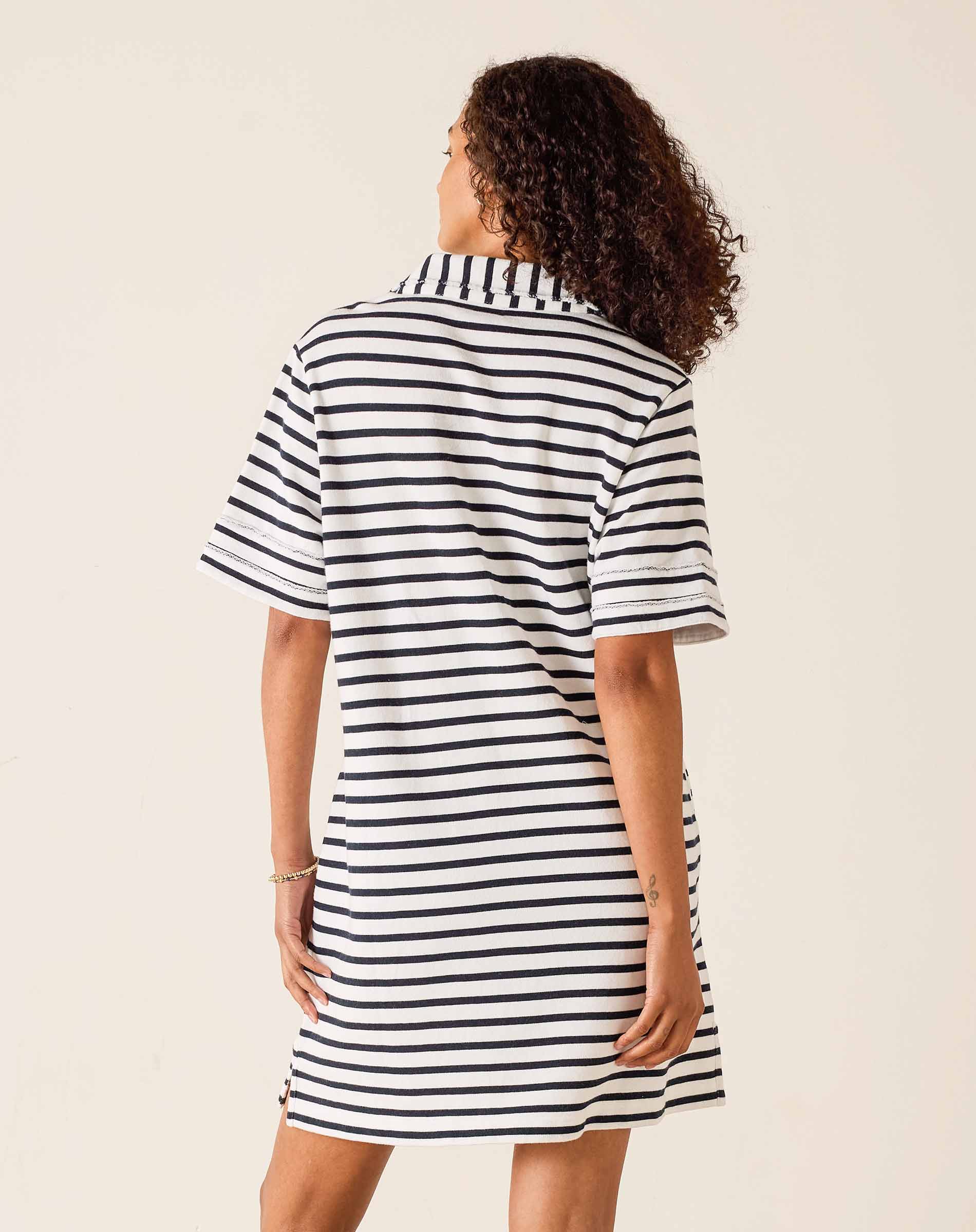 Woman wearing a black and white striped dress on a beige background