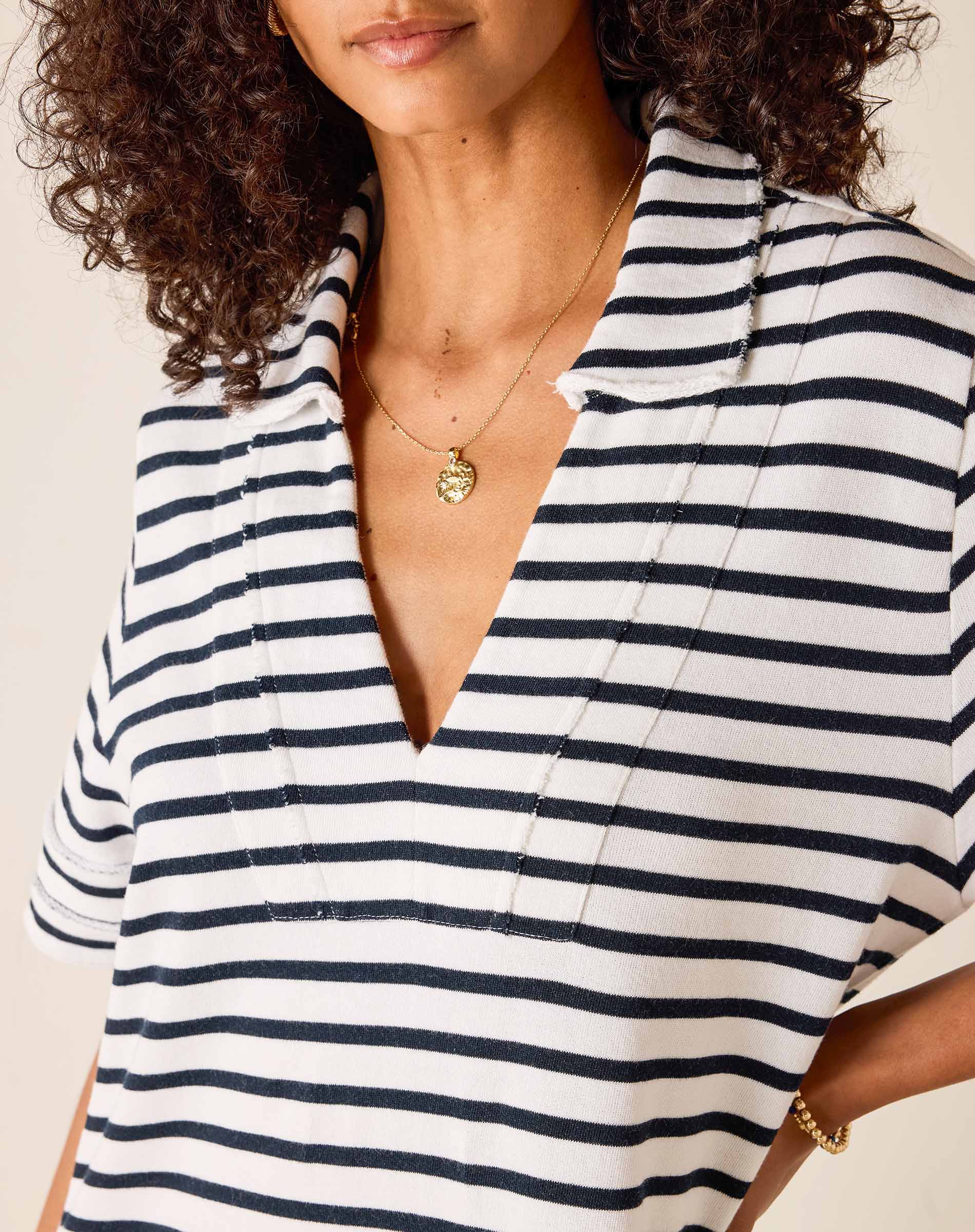Woman wearing a black and white striped shirt with a plain background