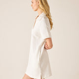 Woman wearing a white dress against a plain background