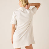 Woman wearing a white dress against a plain background