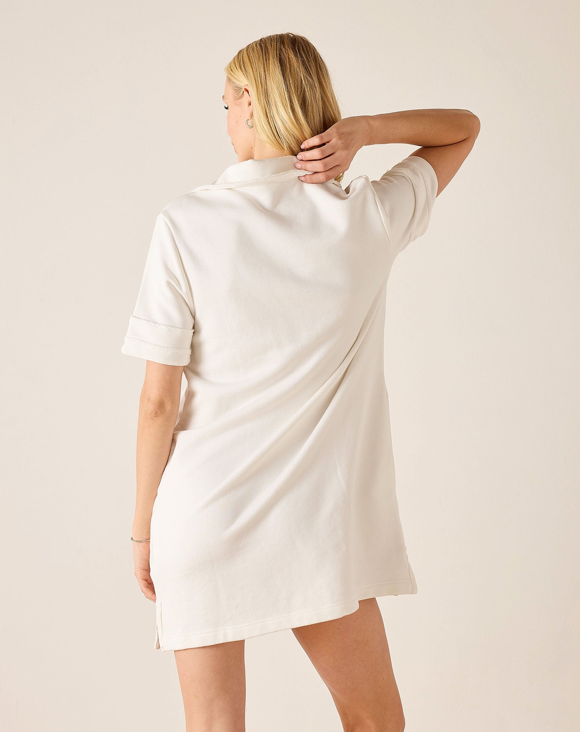 Woman wearing a white dress against a plain background