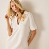 Woman wearing a white dress against a plain background