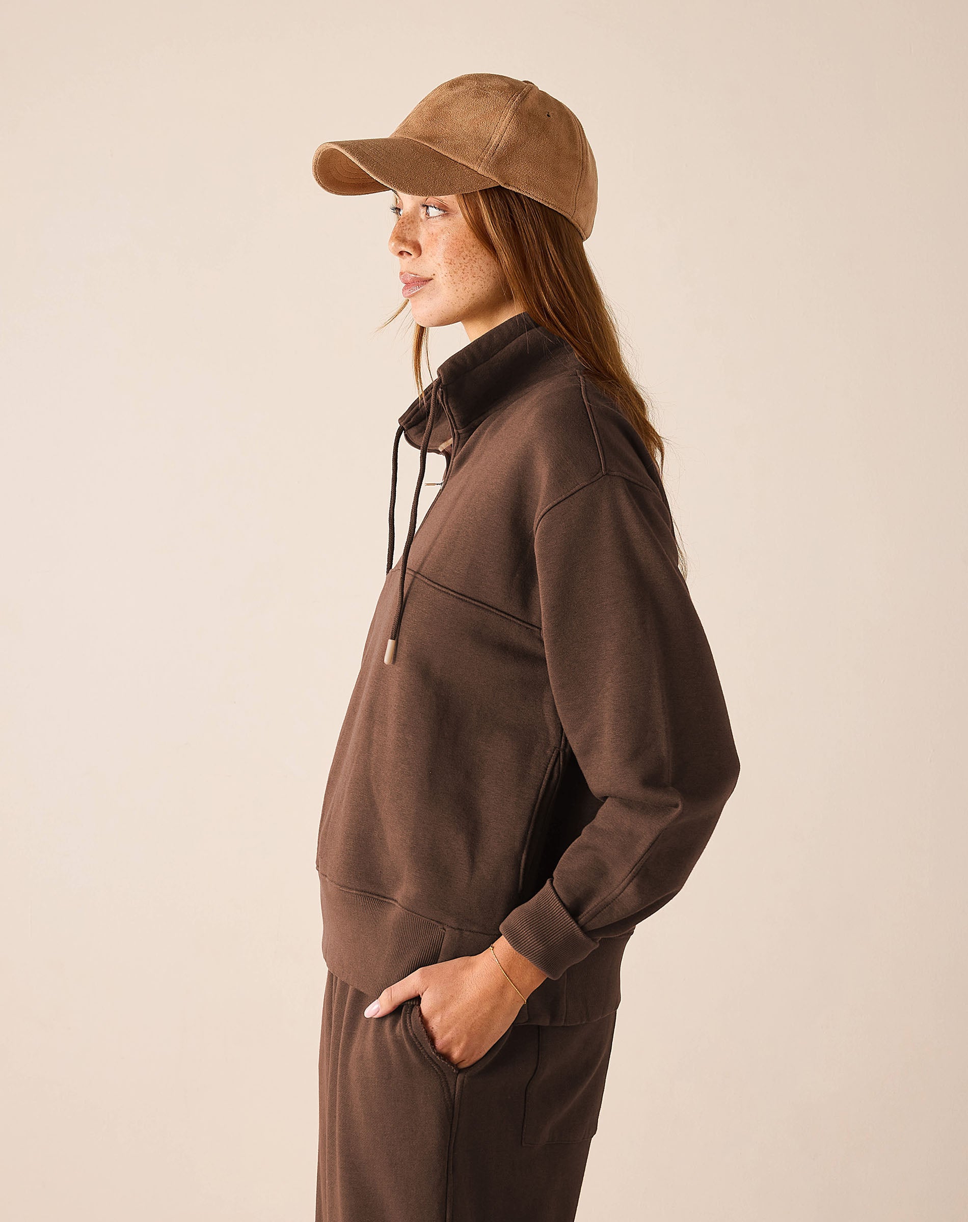 Espresso brown quarter-zip knit top featuring a stand collar and relaxed fit.