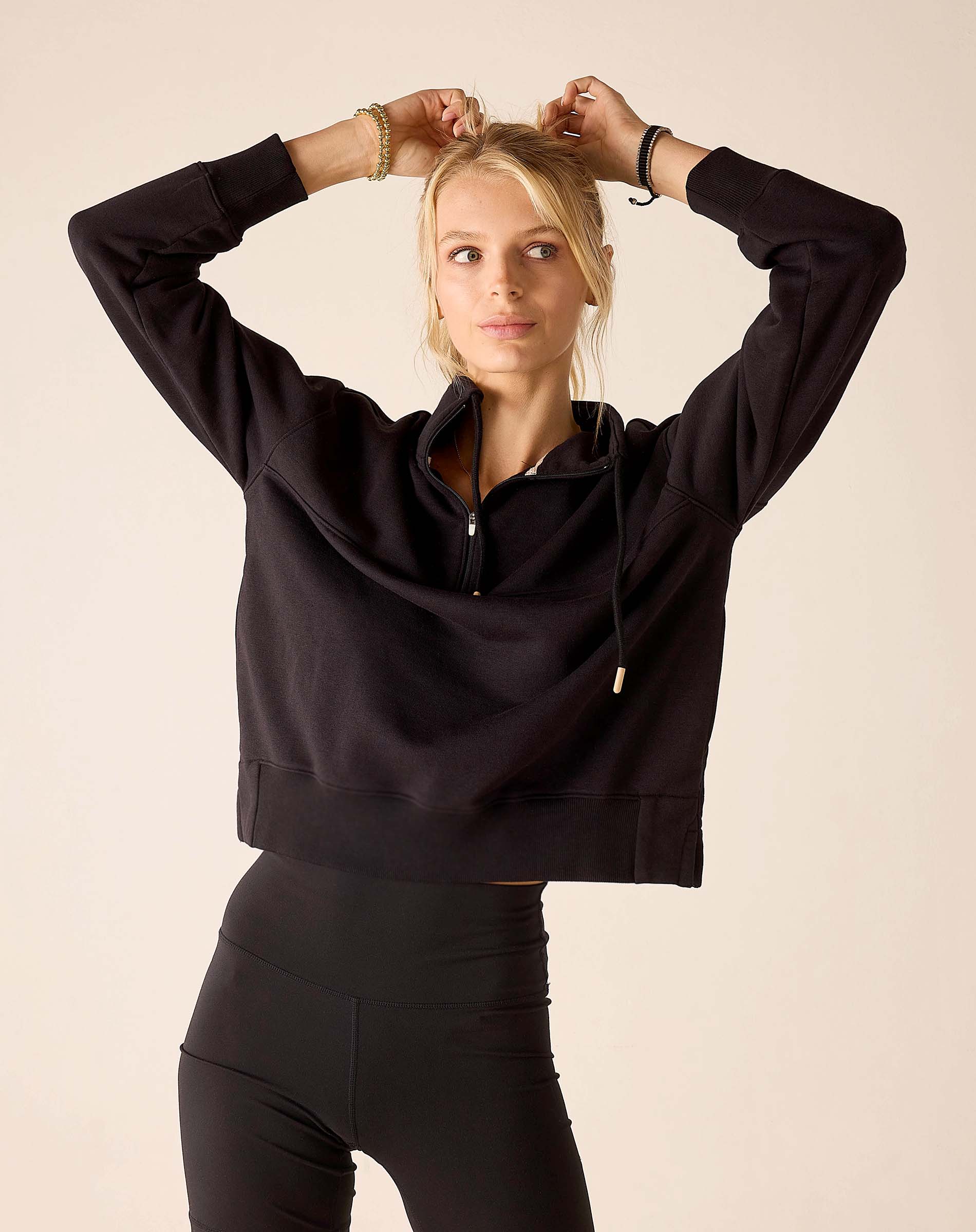 Black quarter-zip sweatshirt with a zip neck and drawstring hood.