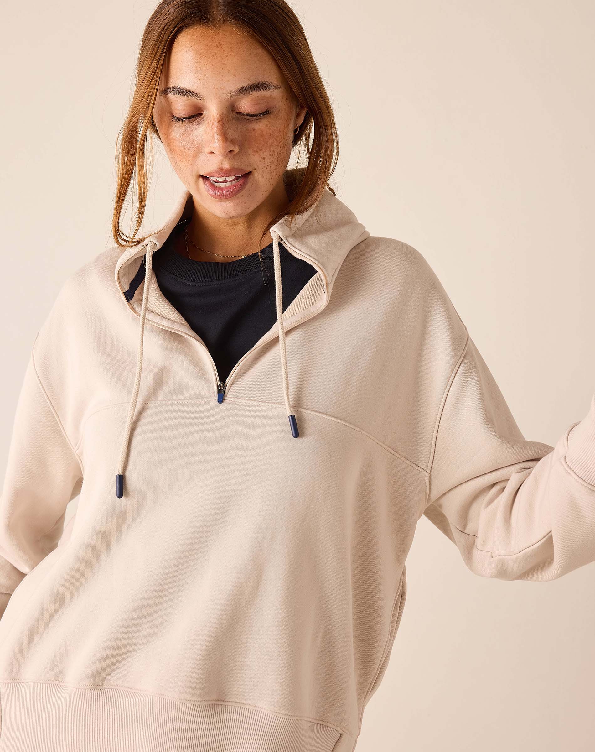 Bone quarter-zip sweatshirt with a hood and drawstring ties.