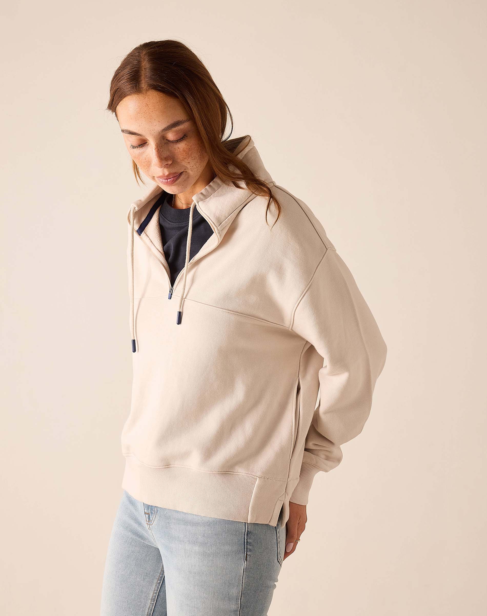 Bone quarter-zip sweatshirt with a tall collar and long sleeves.