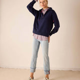 Cadet blue quarter-zip sweatshirt with a layered look and light wash jeans.