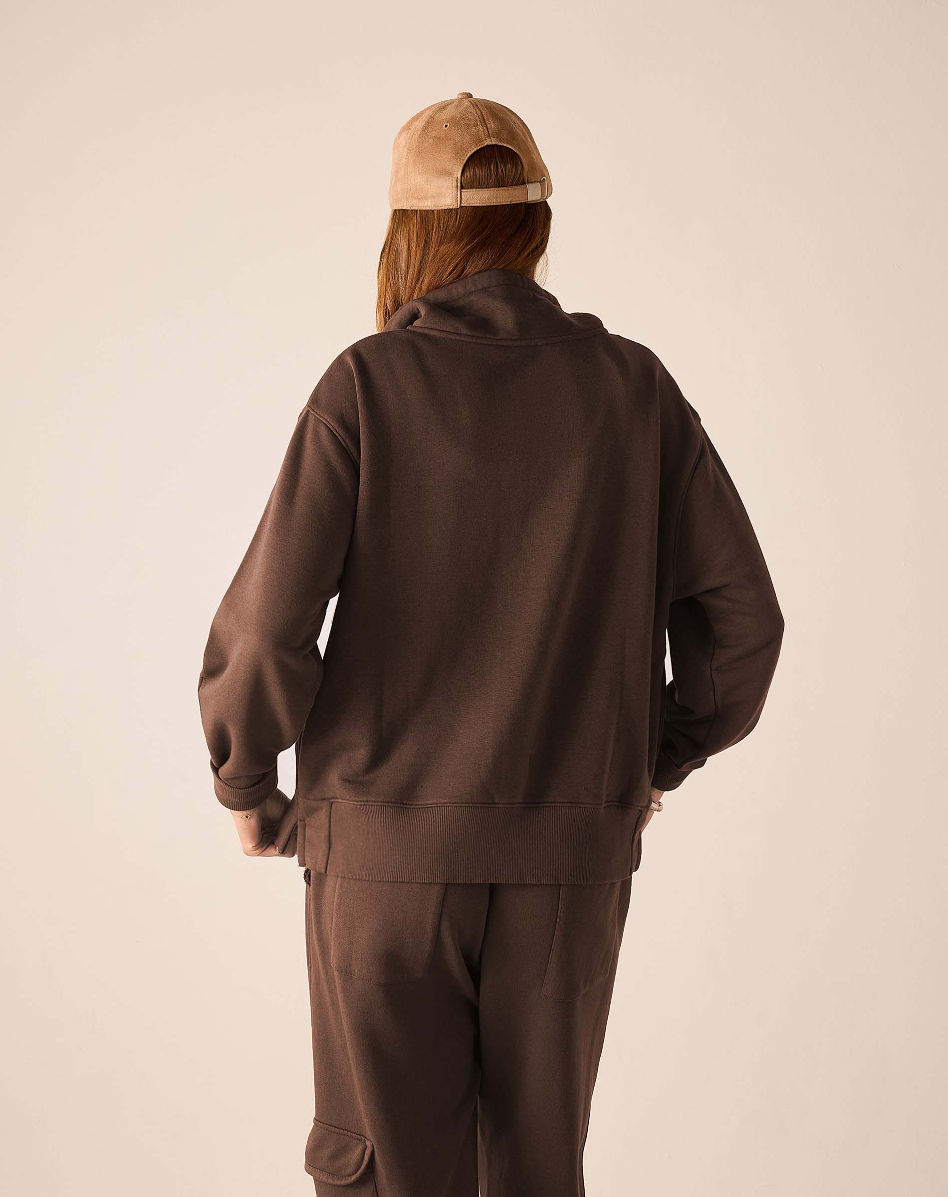Back view of the espresso quarter-zip sweatshirt with a relaxed fit and ribbed cuffs.
