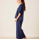 Woman wearing a navy blue outfit against a white background