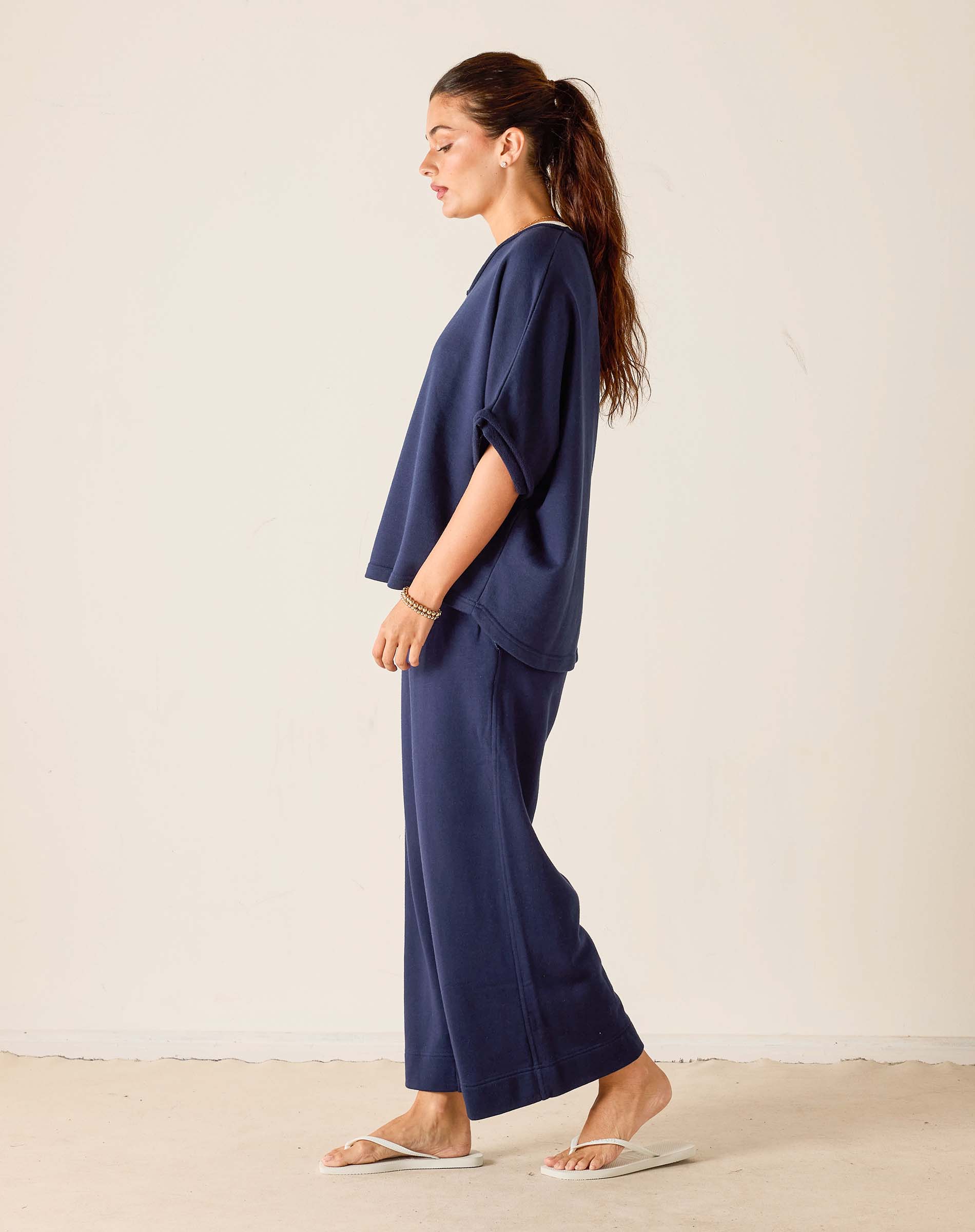 Woman wearing a navy blue outfit against a white background