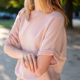 Woman wearing a light pink dress with a blurred outdoor background