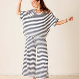Woman wearing a black and white striped outfit on a plain background