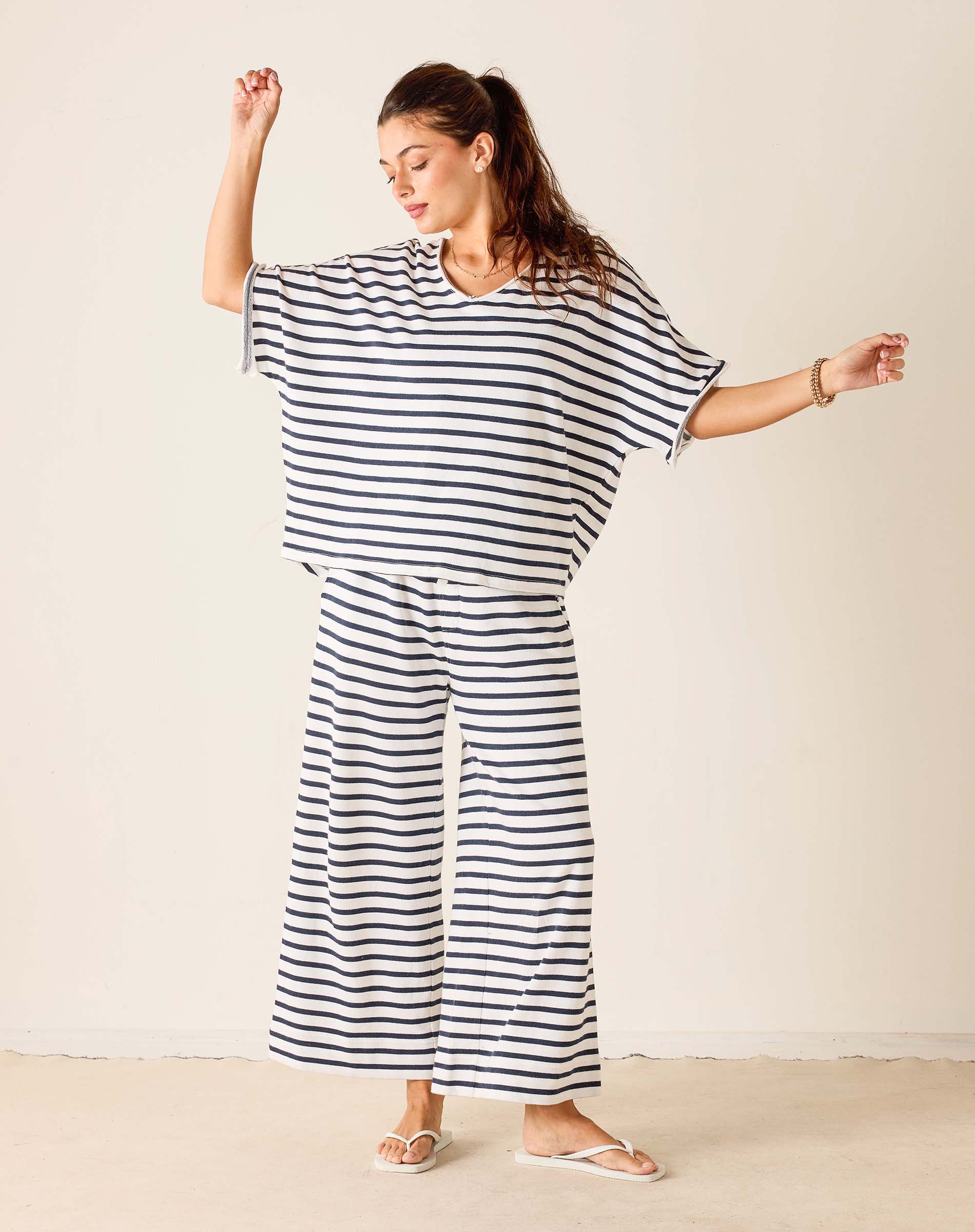 Woman wearing a black and white striped outfit on a plain background
