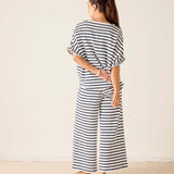 Woman wearing a black and white striped outfit against a plain background