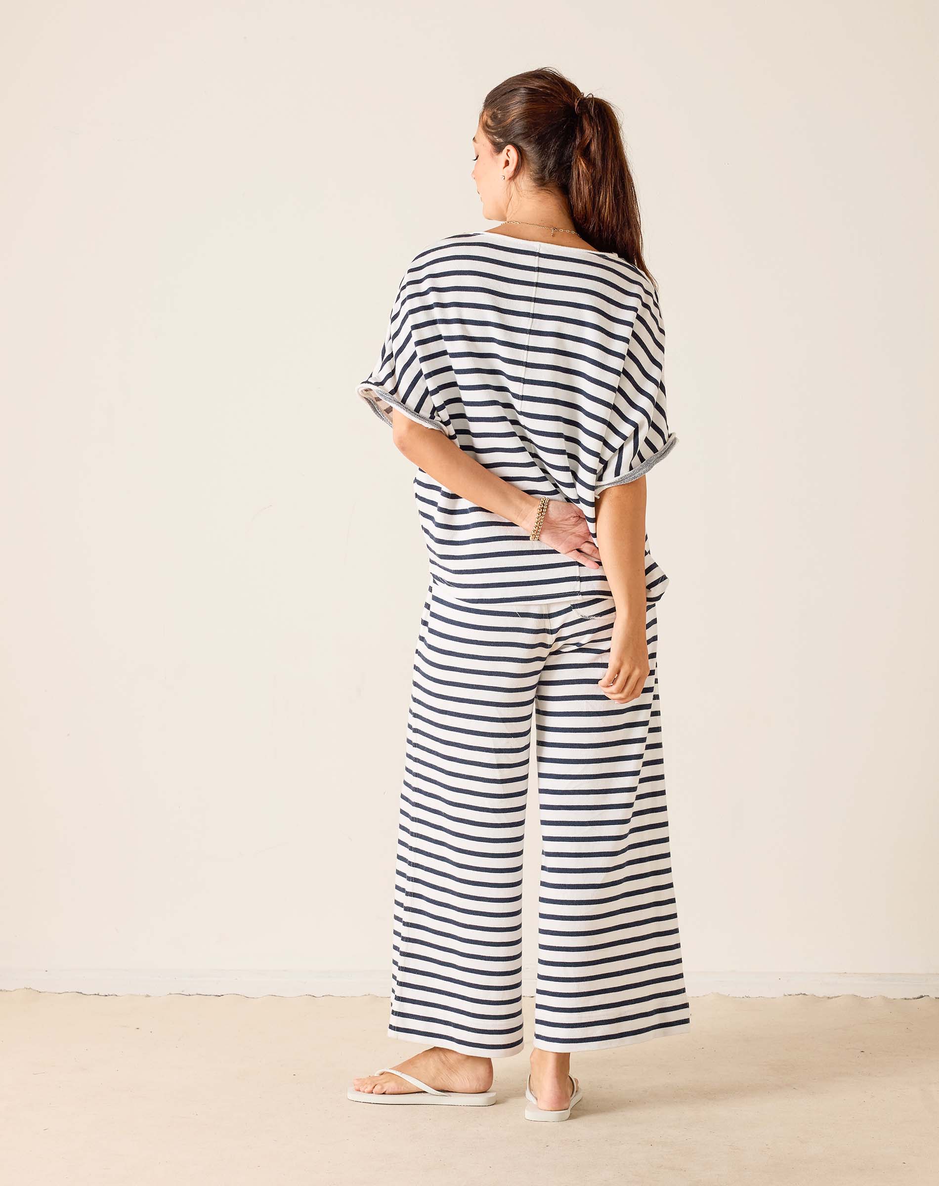 Woman wearing a black and white striped outfit against a plain background