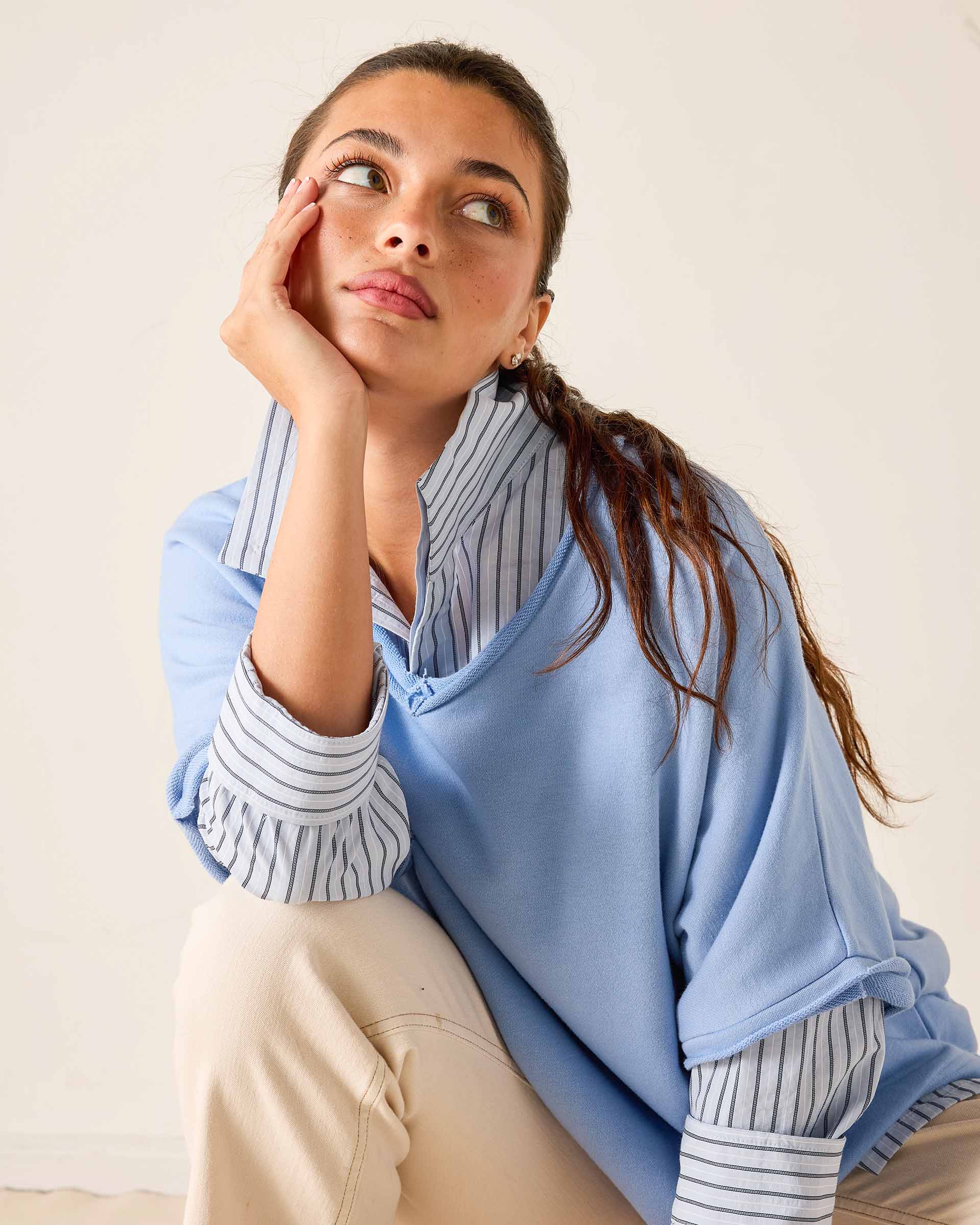 Woman wearing a light blue scarf over her shoulders with a neutral background