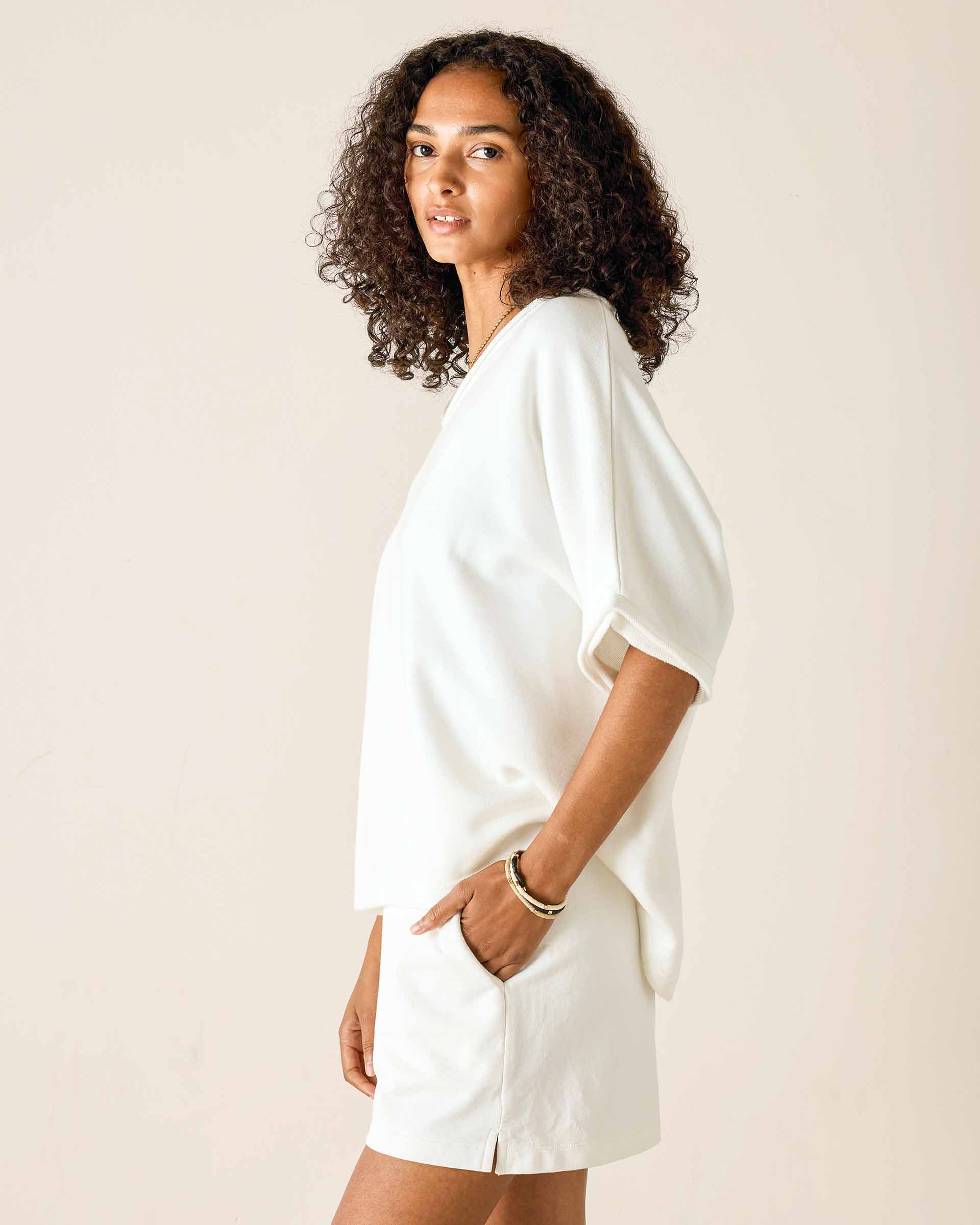 Woman wearing a white outfit against a plain background
