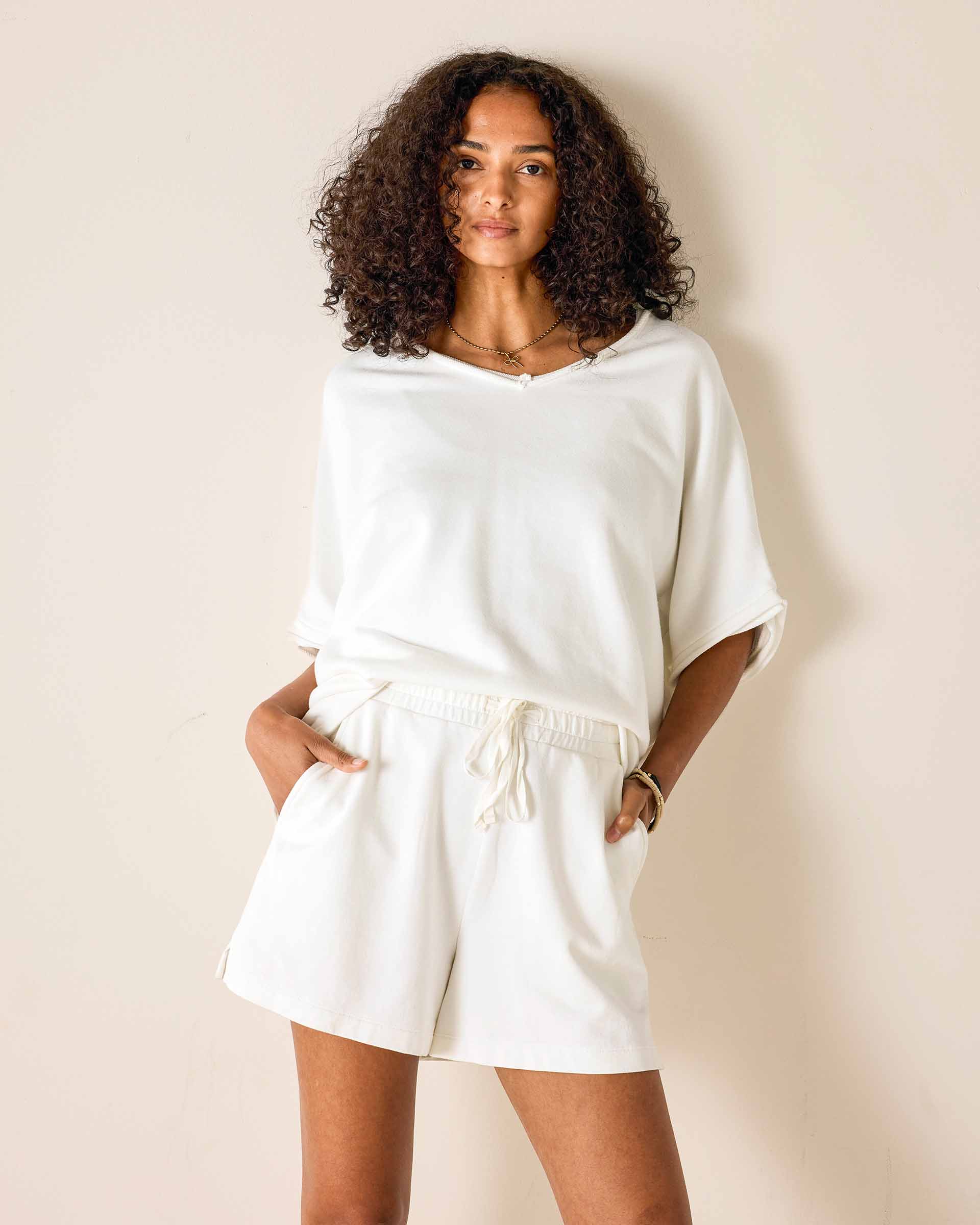 Woman wearing a white outfit against a plain background