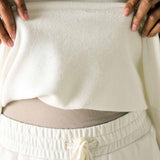 Person wearing a cream-colored outfit with a textured fabric pattern.