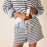 Person wearing a striped shirt and shorts with a white background