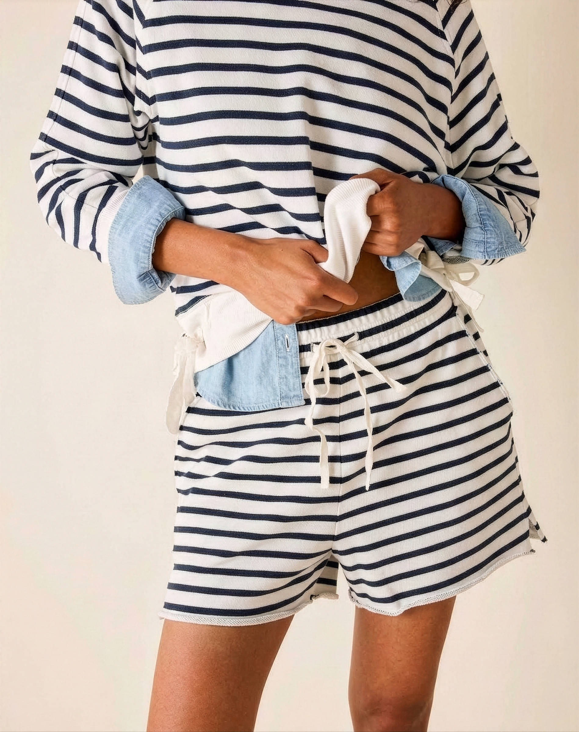Person wearing a striped shirt and shorts with a white background