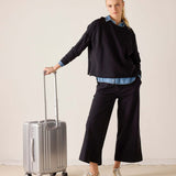 MERSEA ladies' travel-ready black Frenchie side-zip knit top with a relaxed fit and long sleeves. Text: RIMOWA