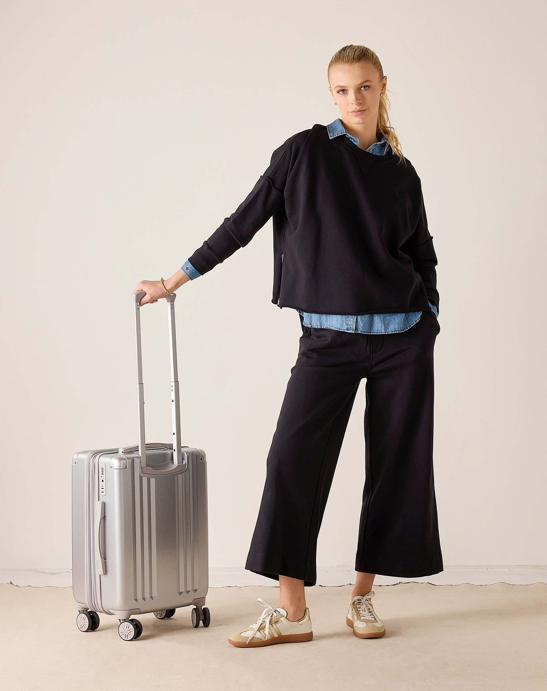 MERSEA ladies' travel-ready black Frenchie side-zip knit top with a relaxed fit and long sleeves. Text: RIMOWA