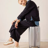 Black frenchie side zip cardigan over a blue shirt and dark trousers.