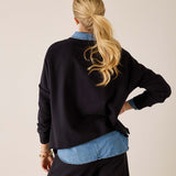Back view of women's travel-friendly black Frenchie top with long sleeves and a layered denim shirt.