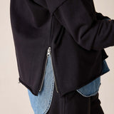 Side view of women's travel-friendly black knit top with a side zip detail.