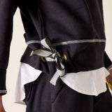 Black outfit with a white shirt and belt detail on a neutral background