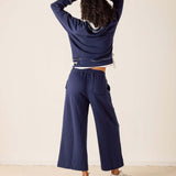 Person wearing a navy blue tracksuit against a white background